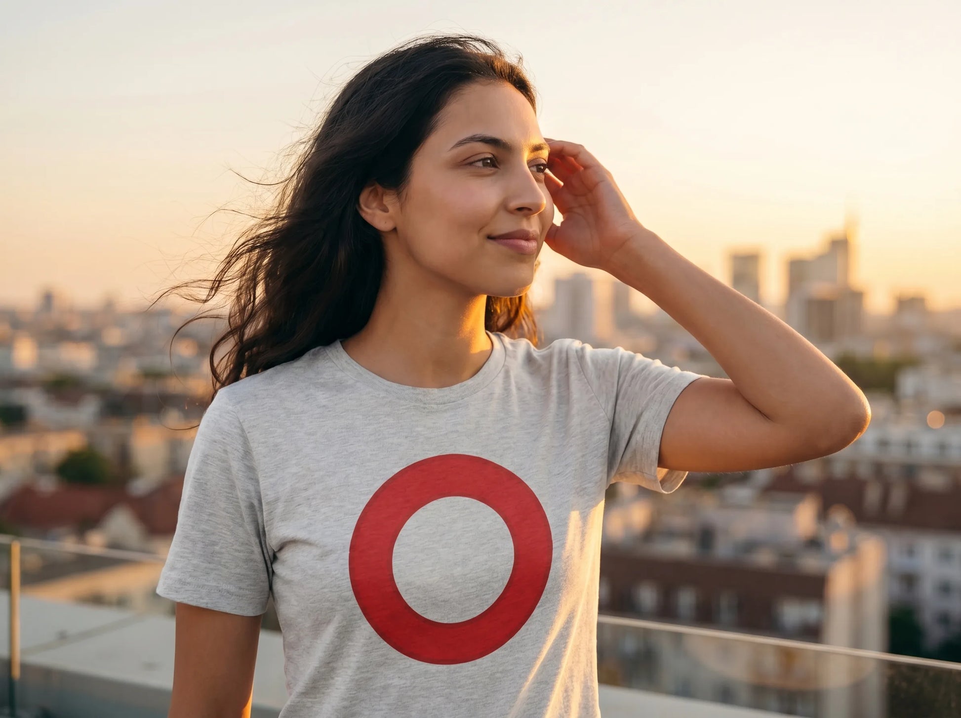 Omi Token Red Circle T-Shirt — OMI emoji tee in ash, modeled at rooftop sunset view