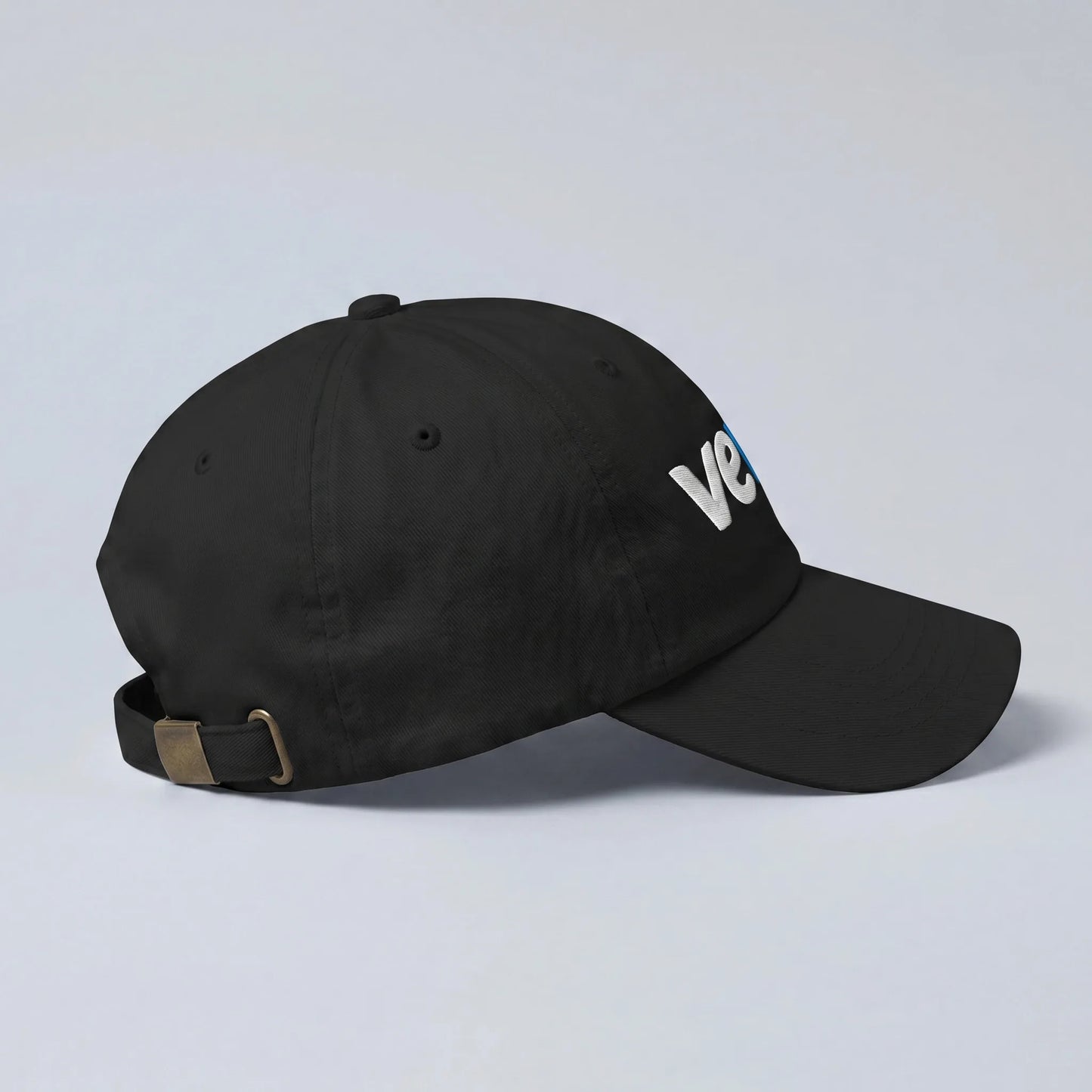 Veve Digital Collectibles New Logo Dad Hat — side view from Common Club, black dad hat with pre-curved bill and brass buckle strap